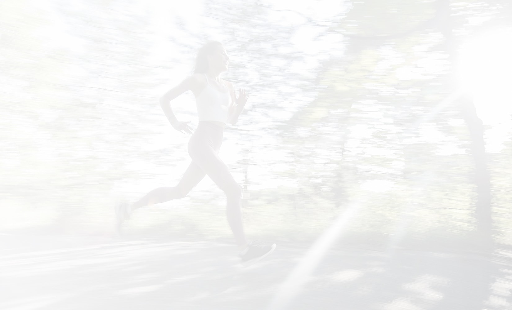 Woman running outdoors in a blurred motion.