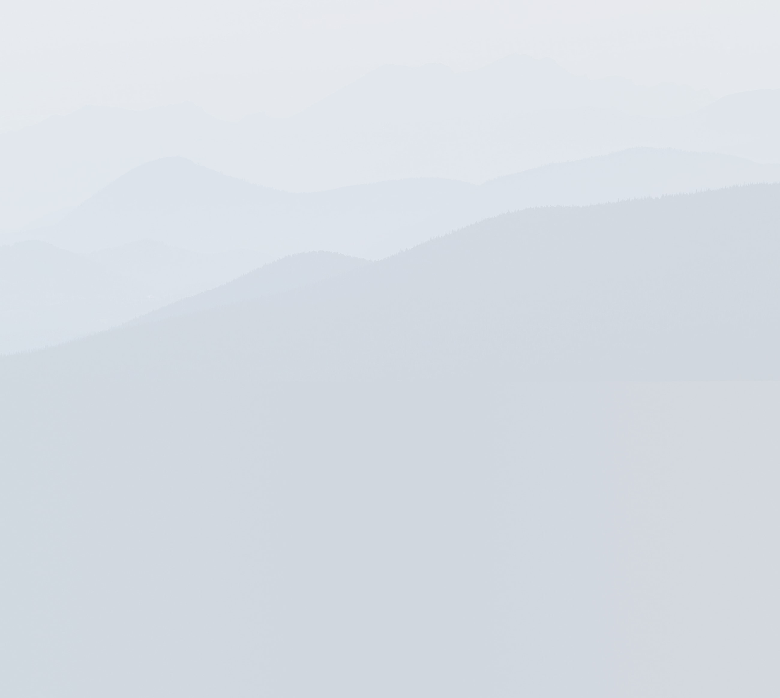 Muted mountain landscape with soft, hazy layers.
