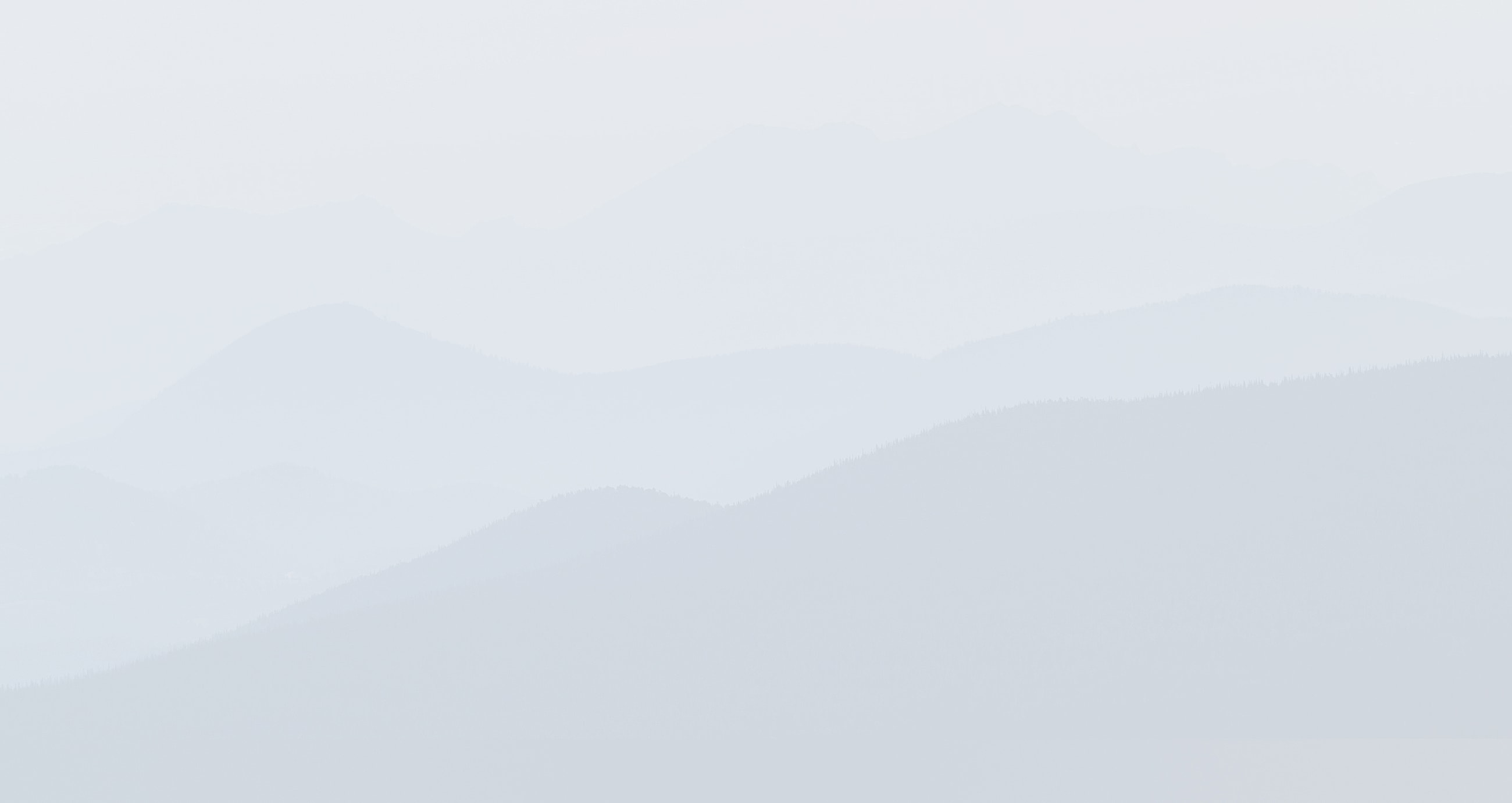 Layered misty mountains in soft gray tones.