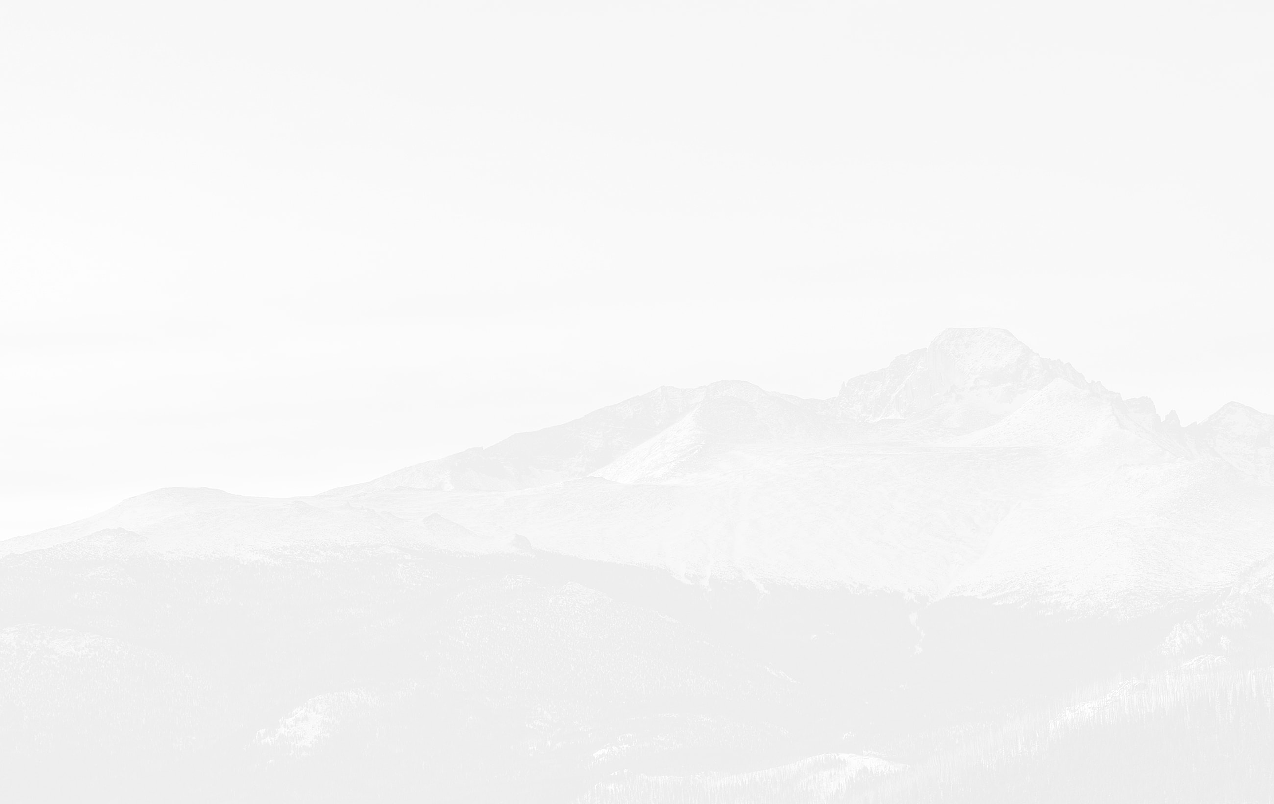 Mountain range silhouette against a cloudy sky.
