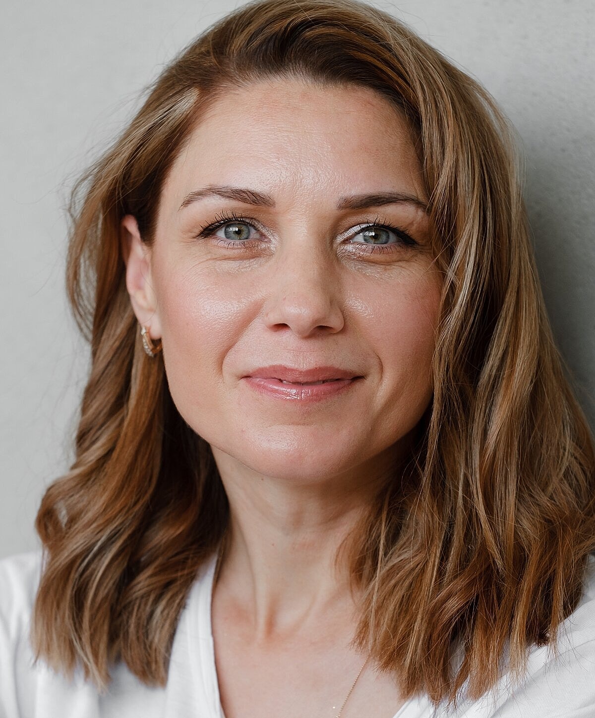 Woman smiling with shoulder-length wavy hair.