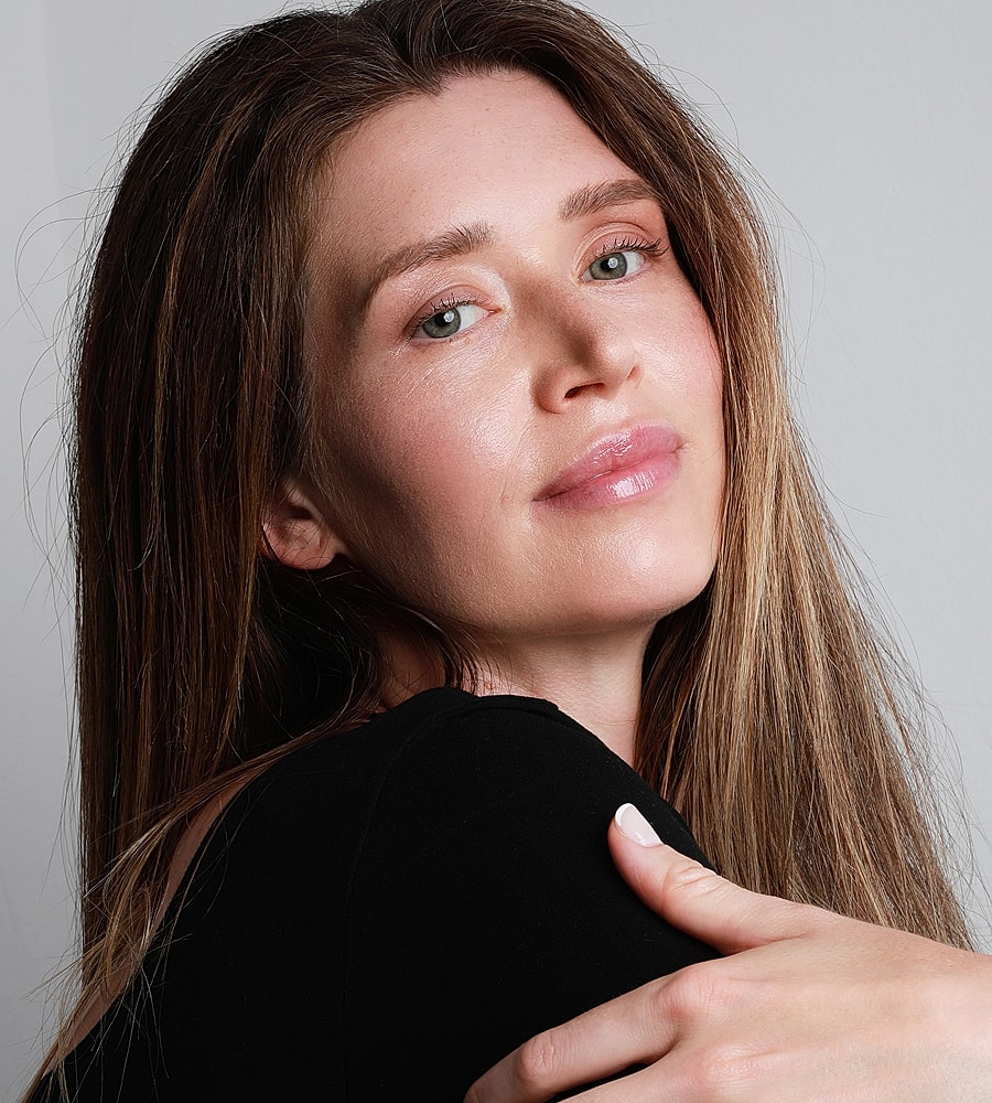 Woman with long hair and natural makeup.
