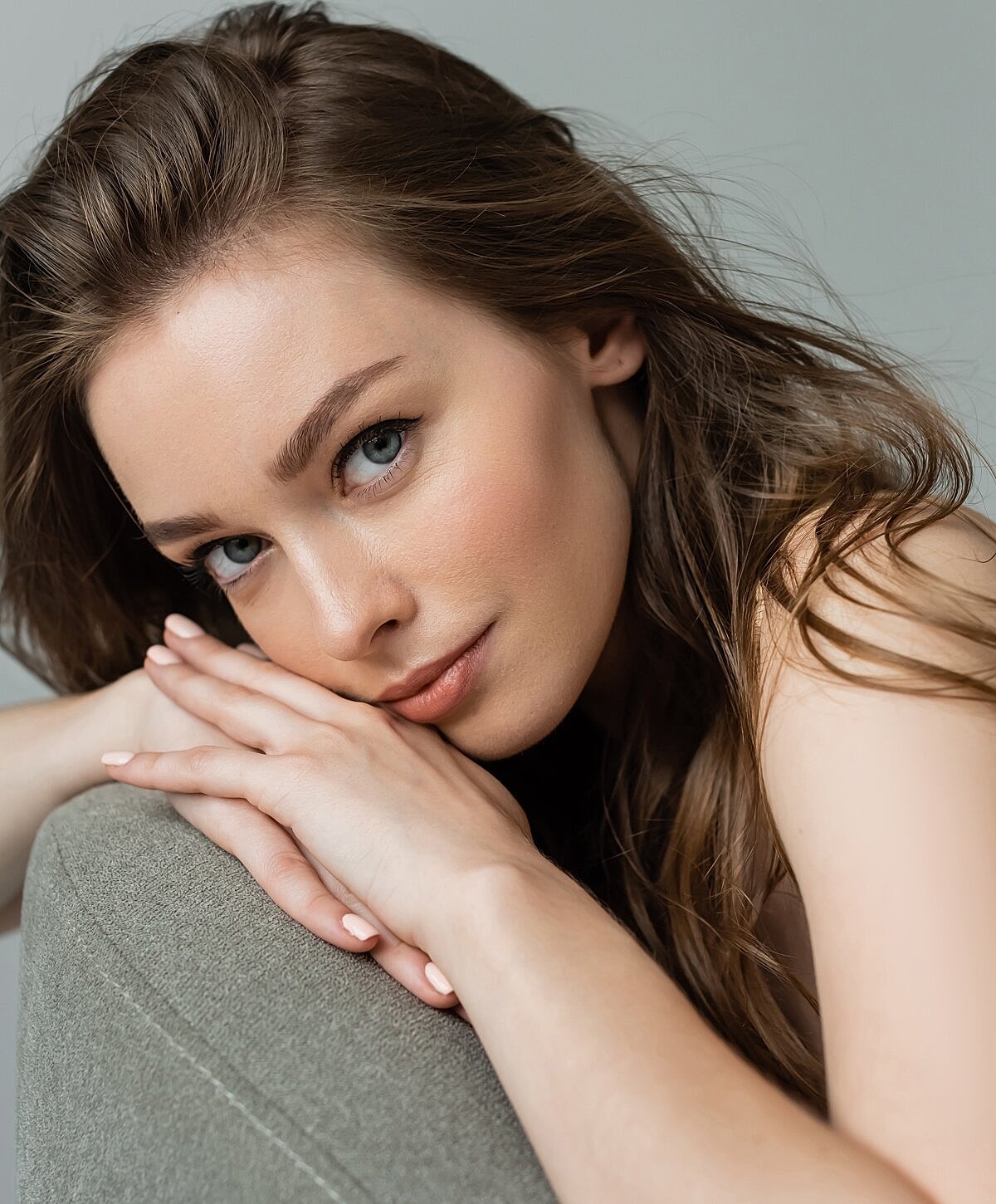 Close-up of a woman resting her chin on hands.