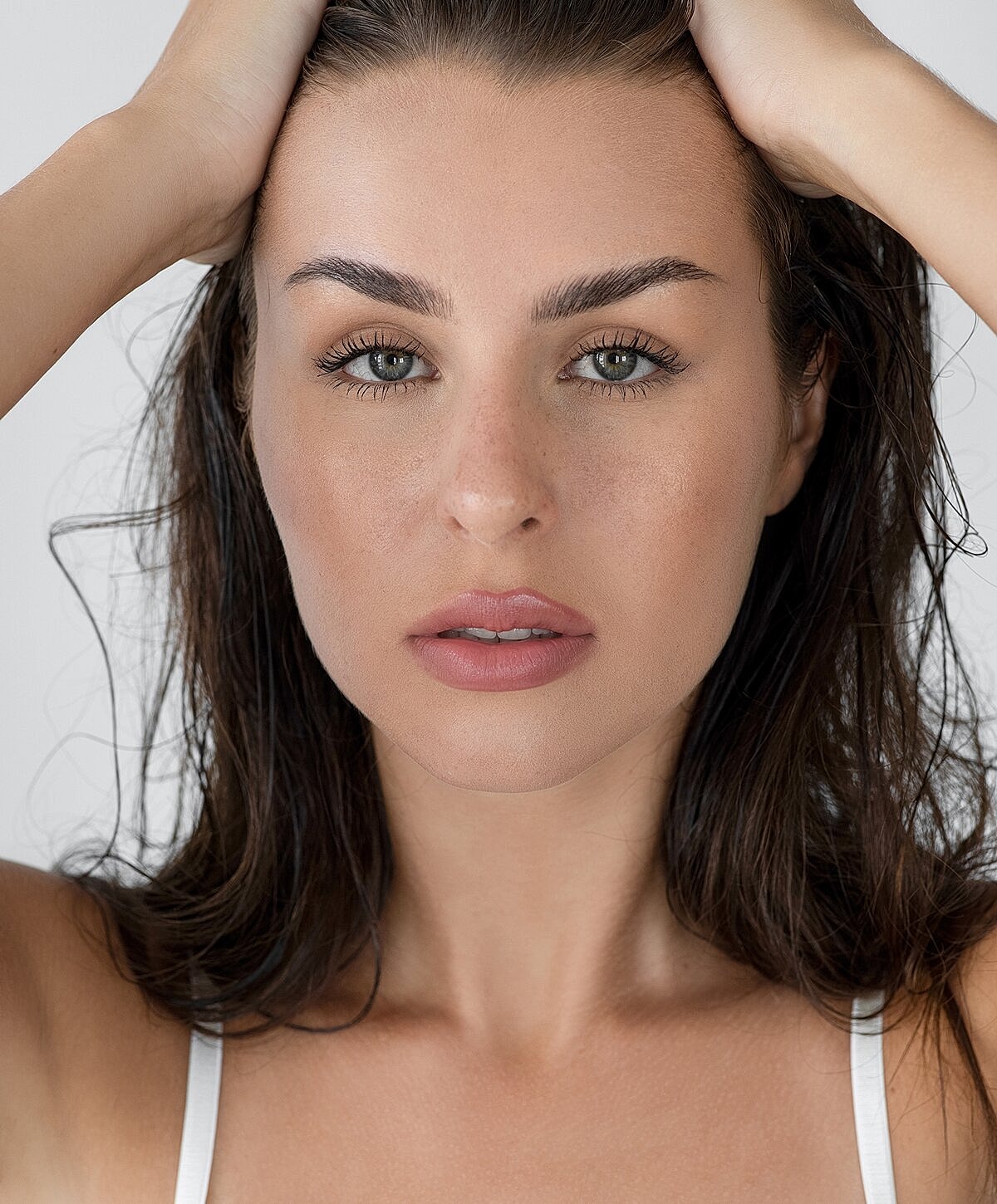 Woman with long hair, natural makeup, neutral expression.
