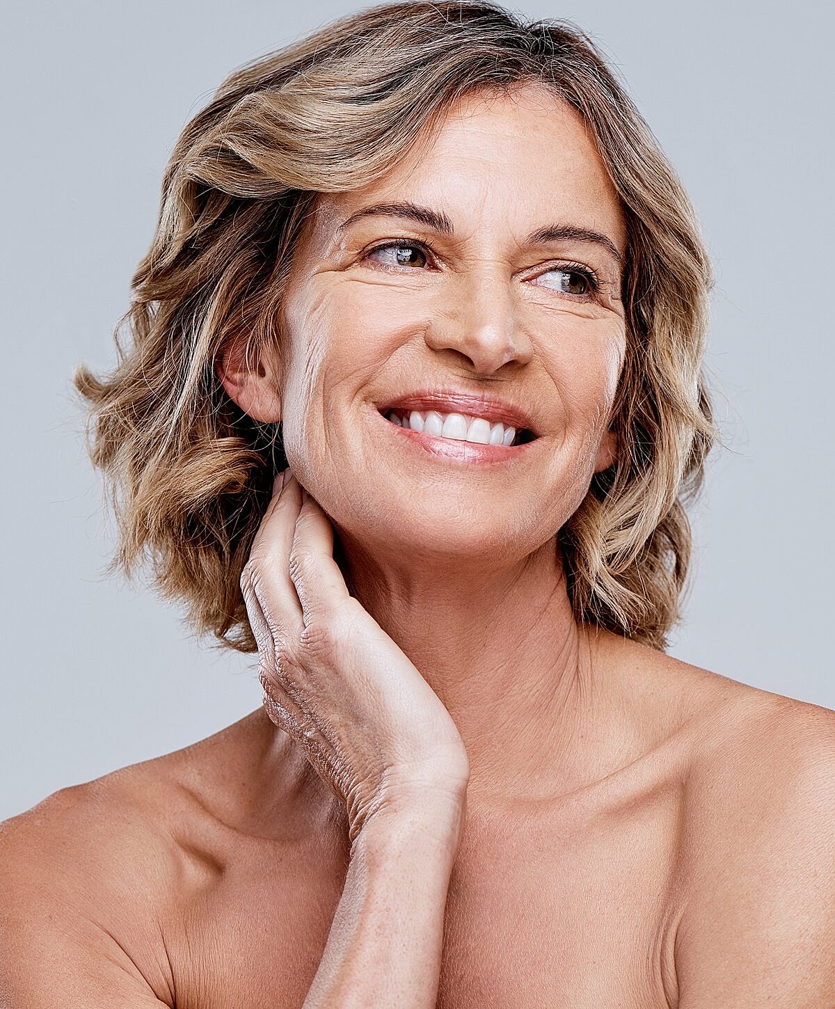 Smiling woman with short, wavy hair.