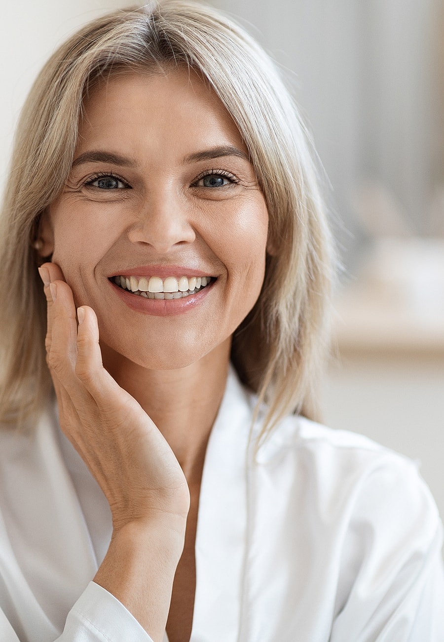 Smiling woman with silky hair and glowing skin.
