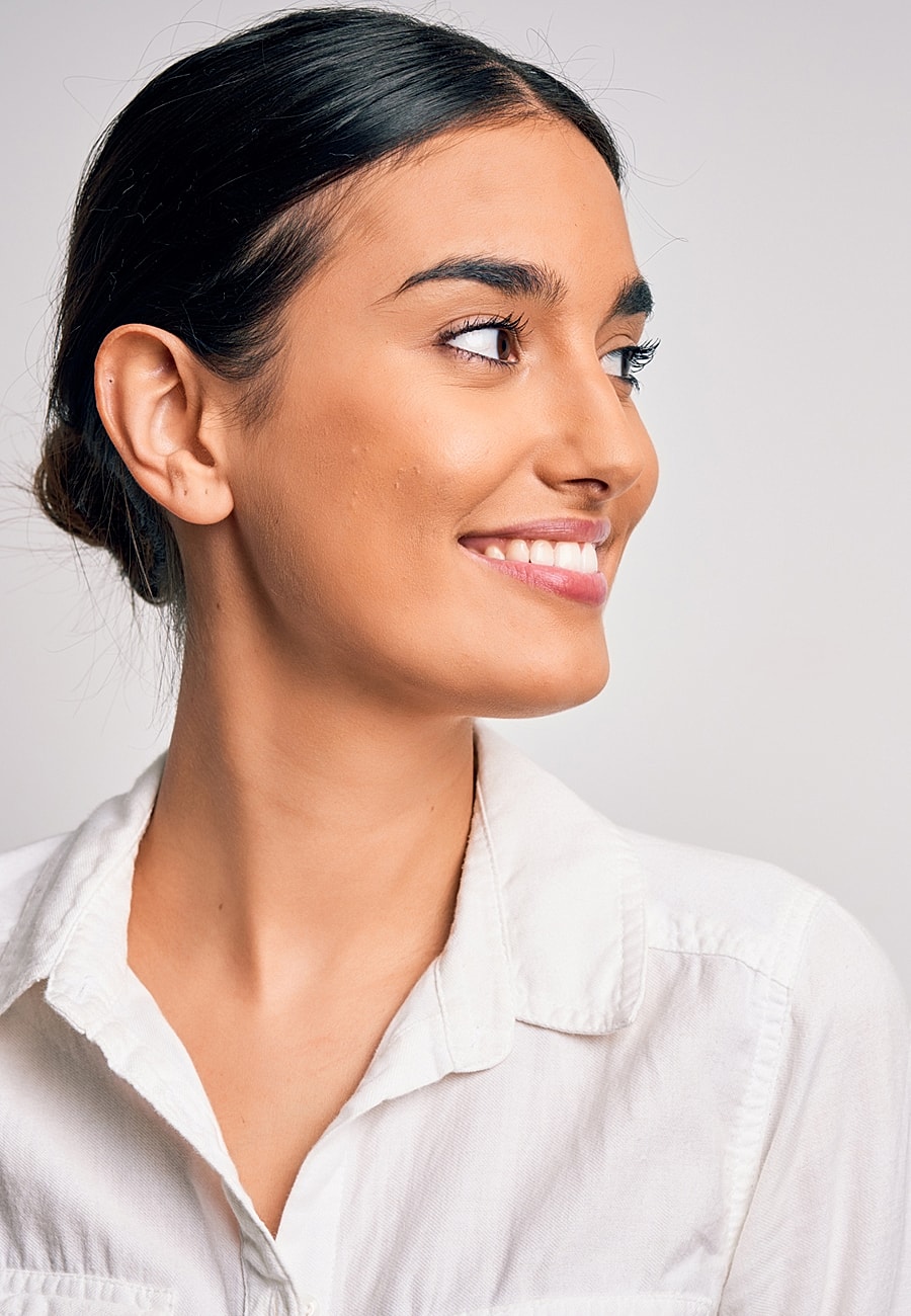 Smiling woman with dark hair in white shirt.