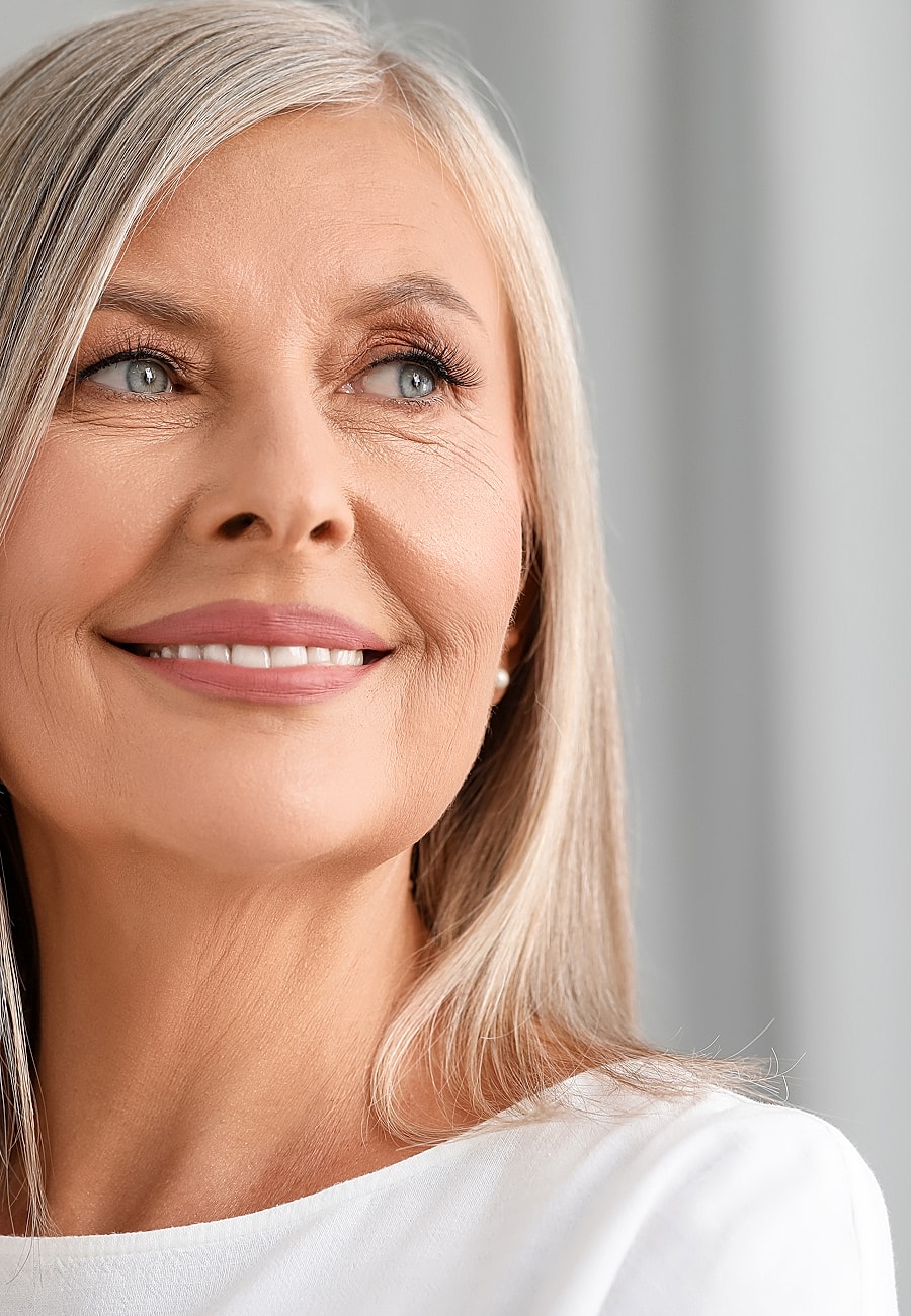 Smiling older woman with long silver hair.