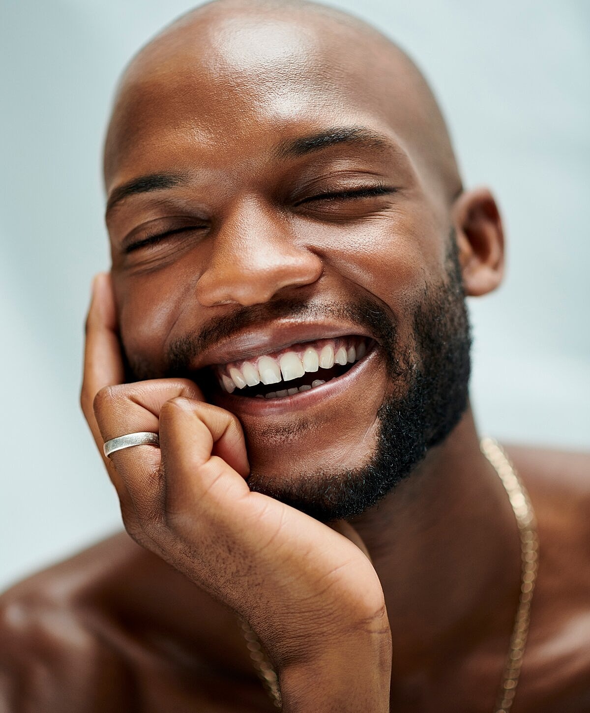 Smiling man resting his chin on hand.