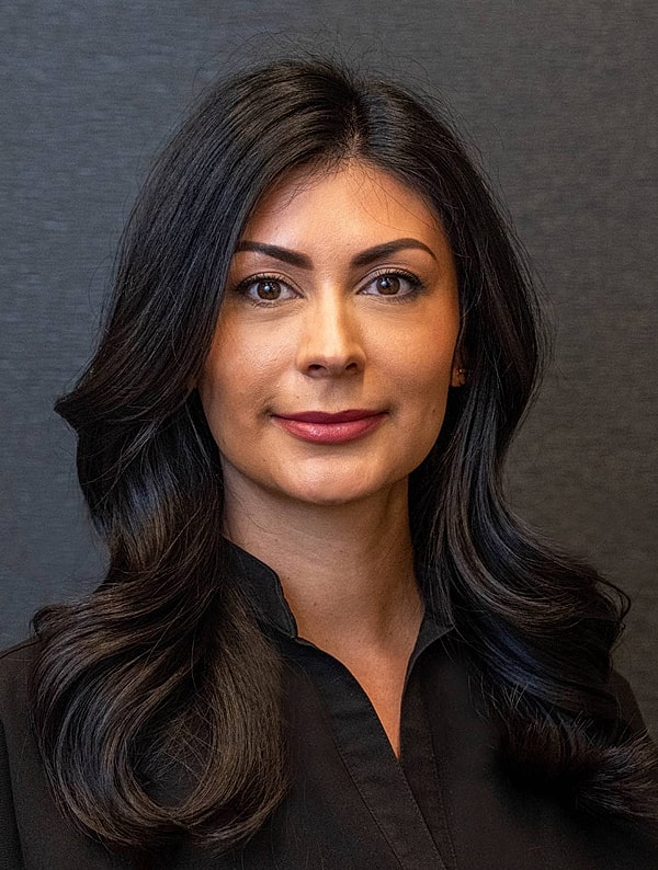 Woman with long black hair, neutral background.