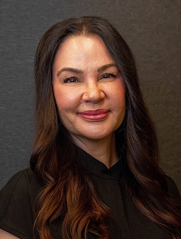 Smiling woman with long dark hair.