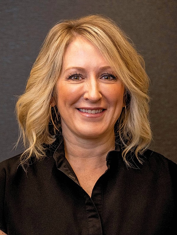 Smiling woman with shoulder-length blonde hair.