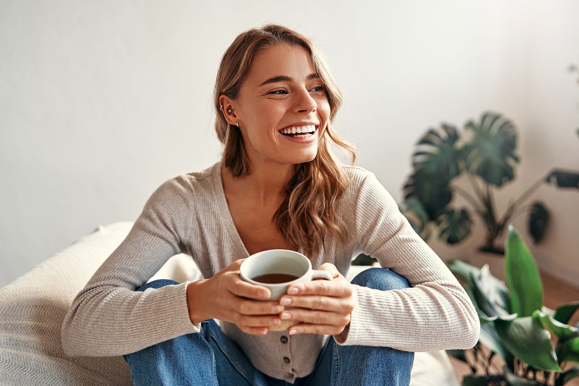 Woman relaxing at home, illustrating the low-downtime recovery period after a MOXI laser treatment.
